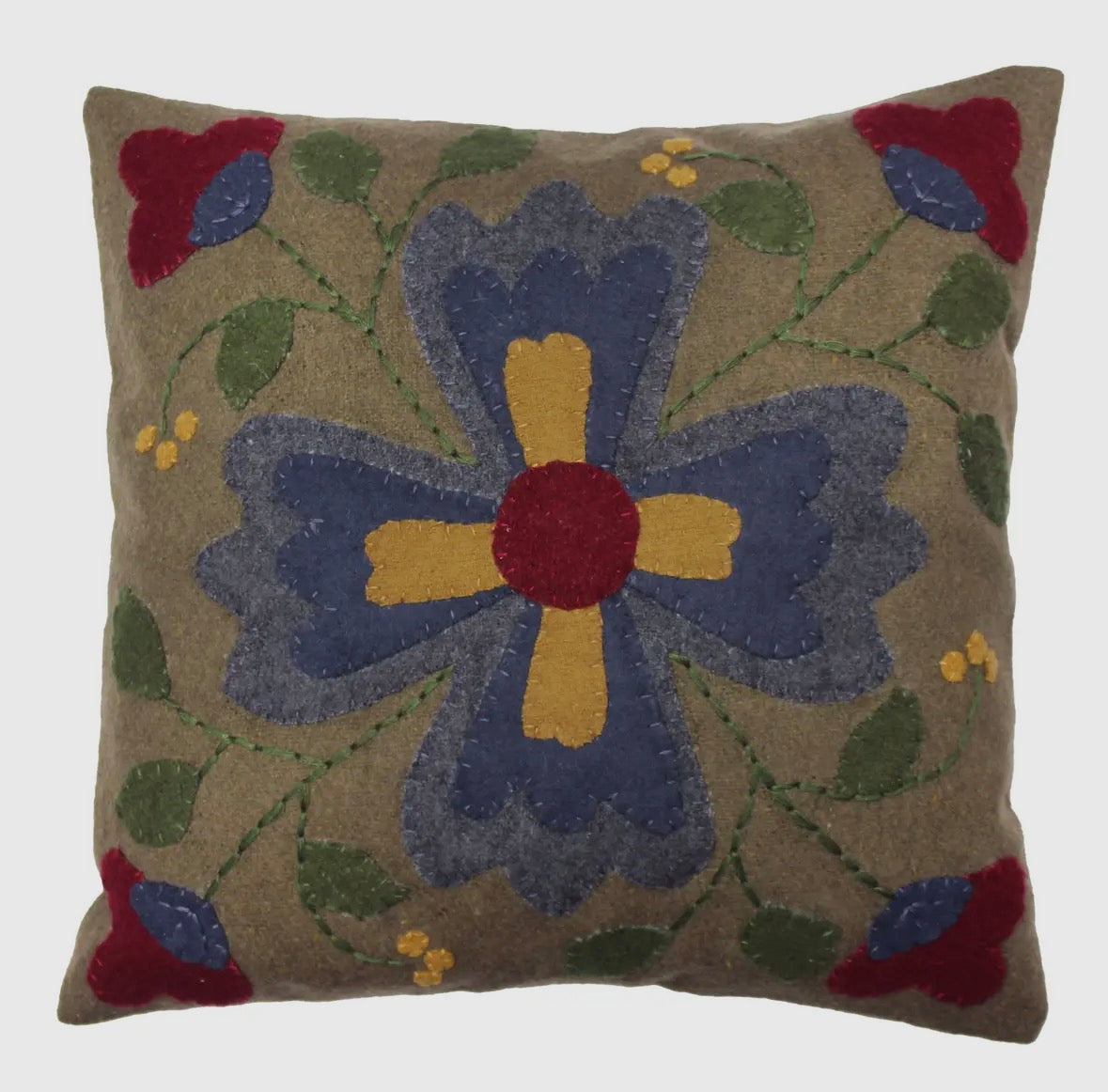 Forager Provisions LTD square wool cushion featuring a primitive folk flower motif in blue, red, and yellow tones.