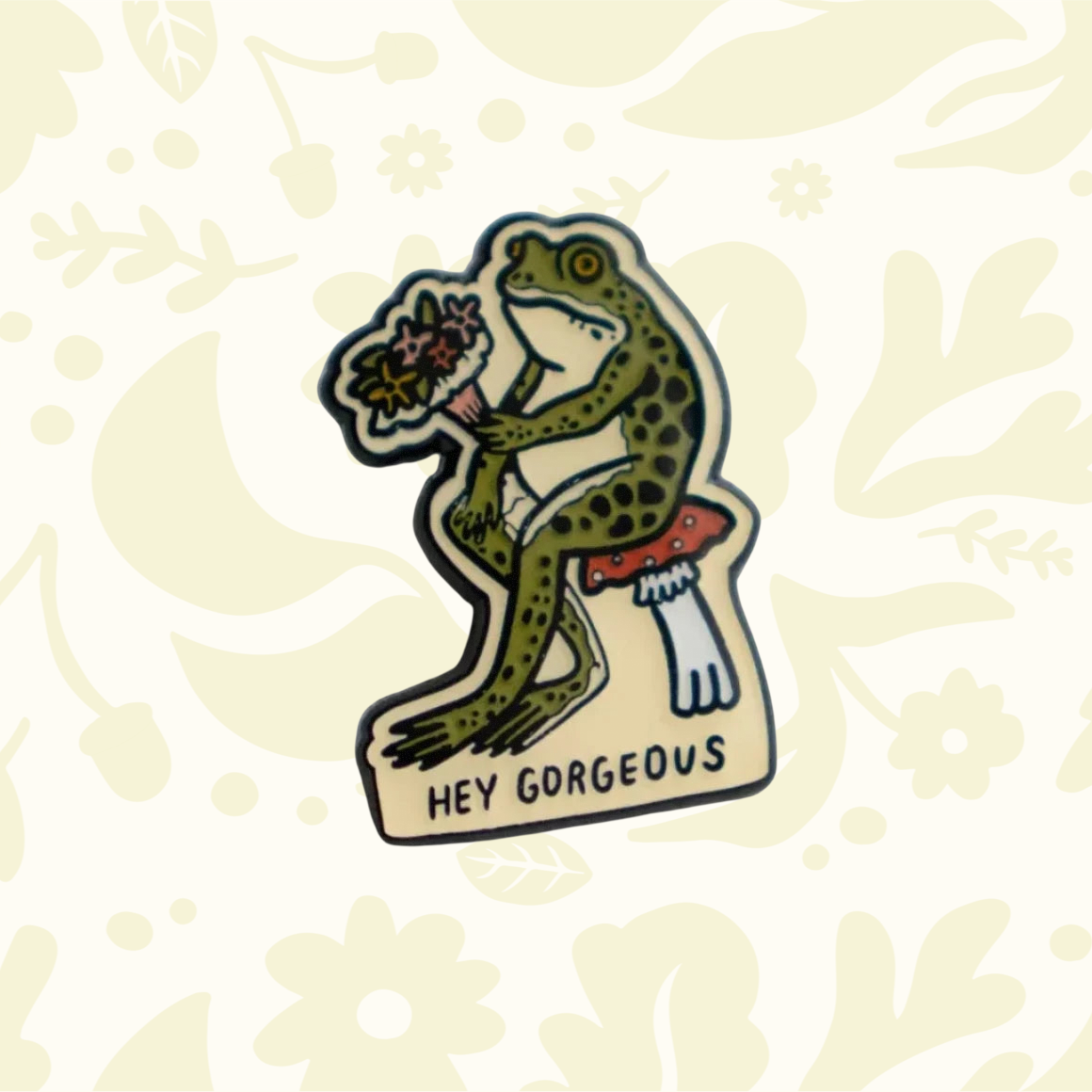 Forager Provisions LTD Stay Home Club enamel pin featuring a frog sitting on a mushroom holding a bouquet of flowers.