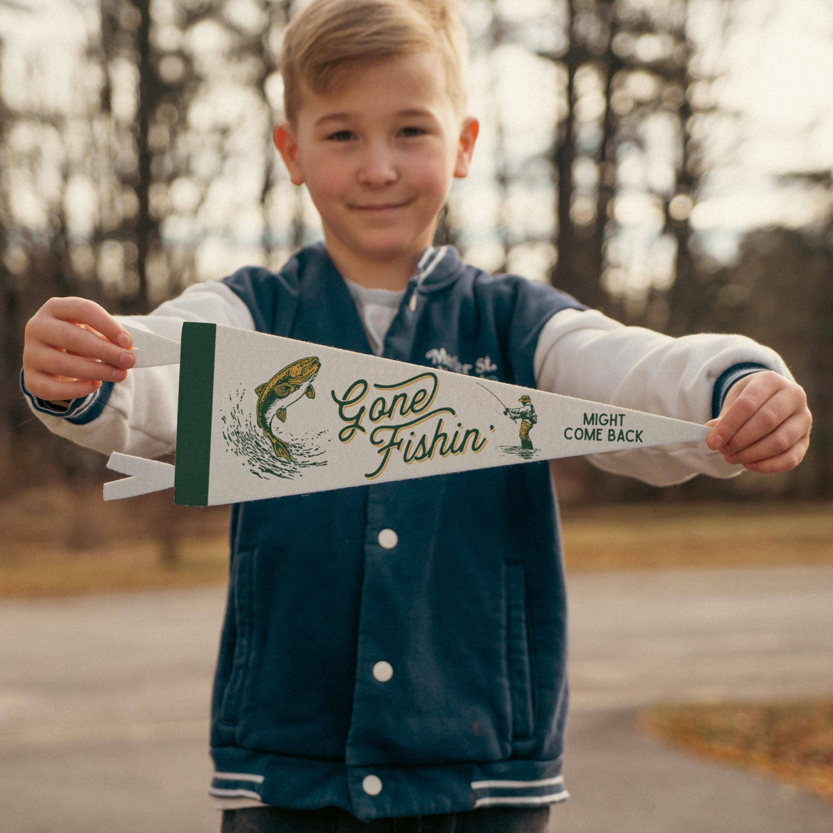 Forager Provisions LTD Benoit's Supply Co. Gone Fishin' felt pennant held by a young boy in a vintage outdoor setting.