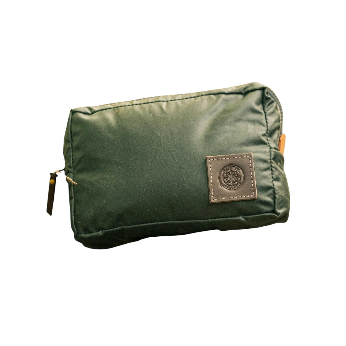 Forager Provisions LTD Journeyman Craft green waxed canvas expedition pouch with leather logo patch on a forest stump