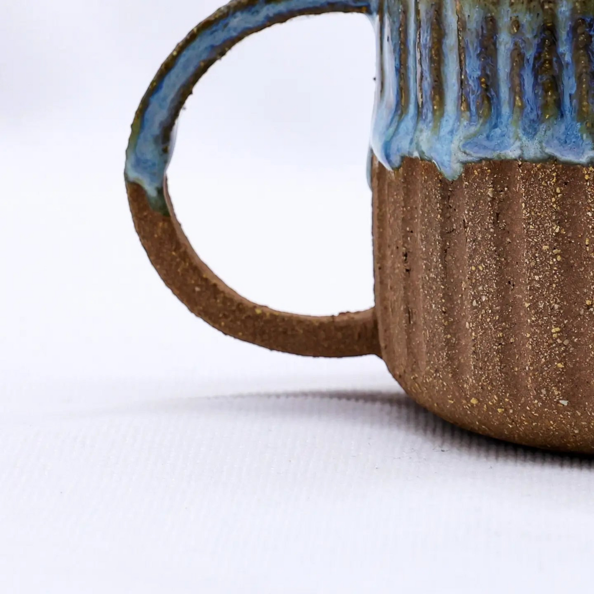 Forager Provisions LTD handmade Ribera Bluvio Arte stoneware mug with a textured brown body and blue drip glaze.