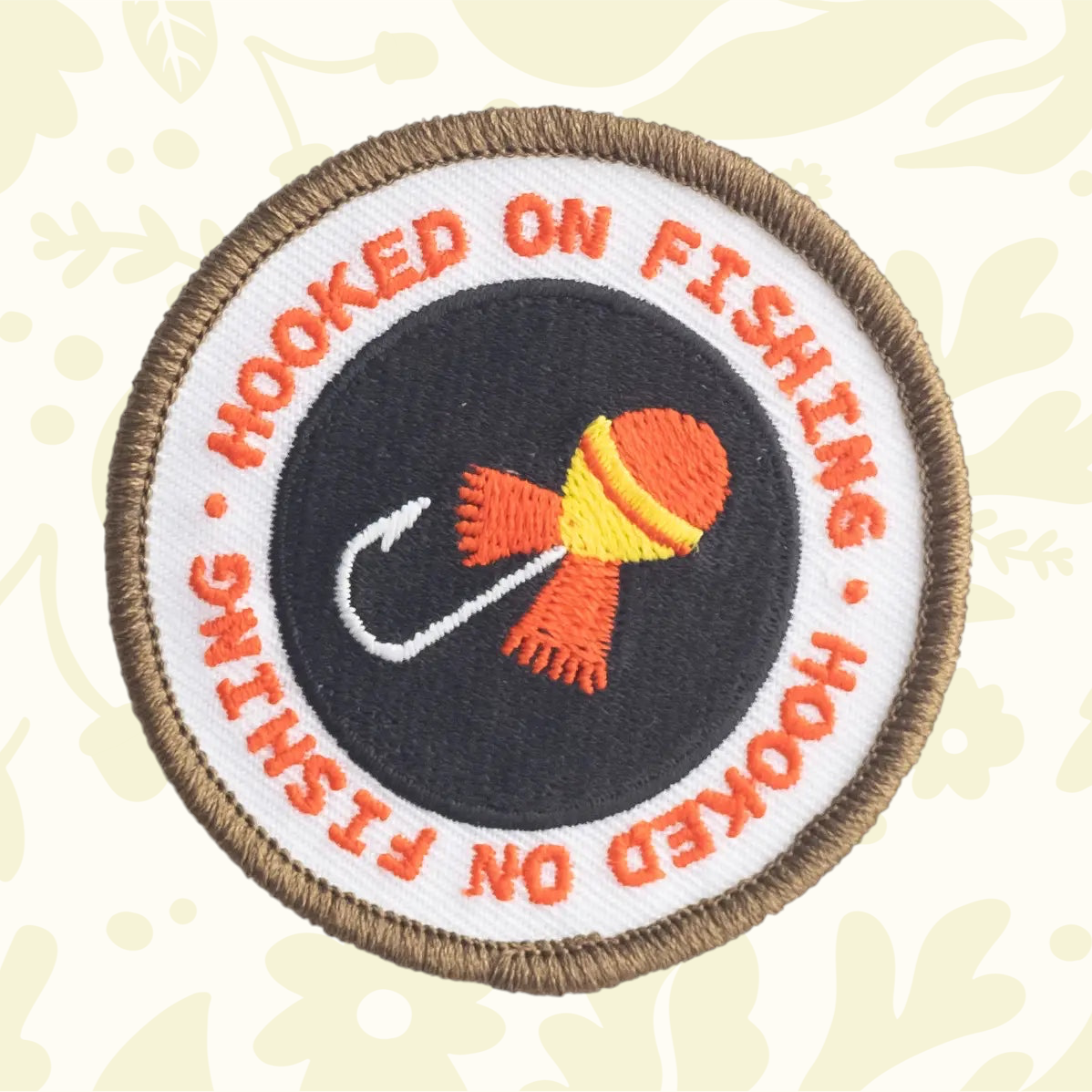 Forager Provisions LTD Hooked On Fishing embroidered patch with a round design, orange text, and a fishing hook icon.
