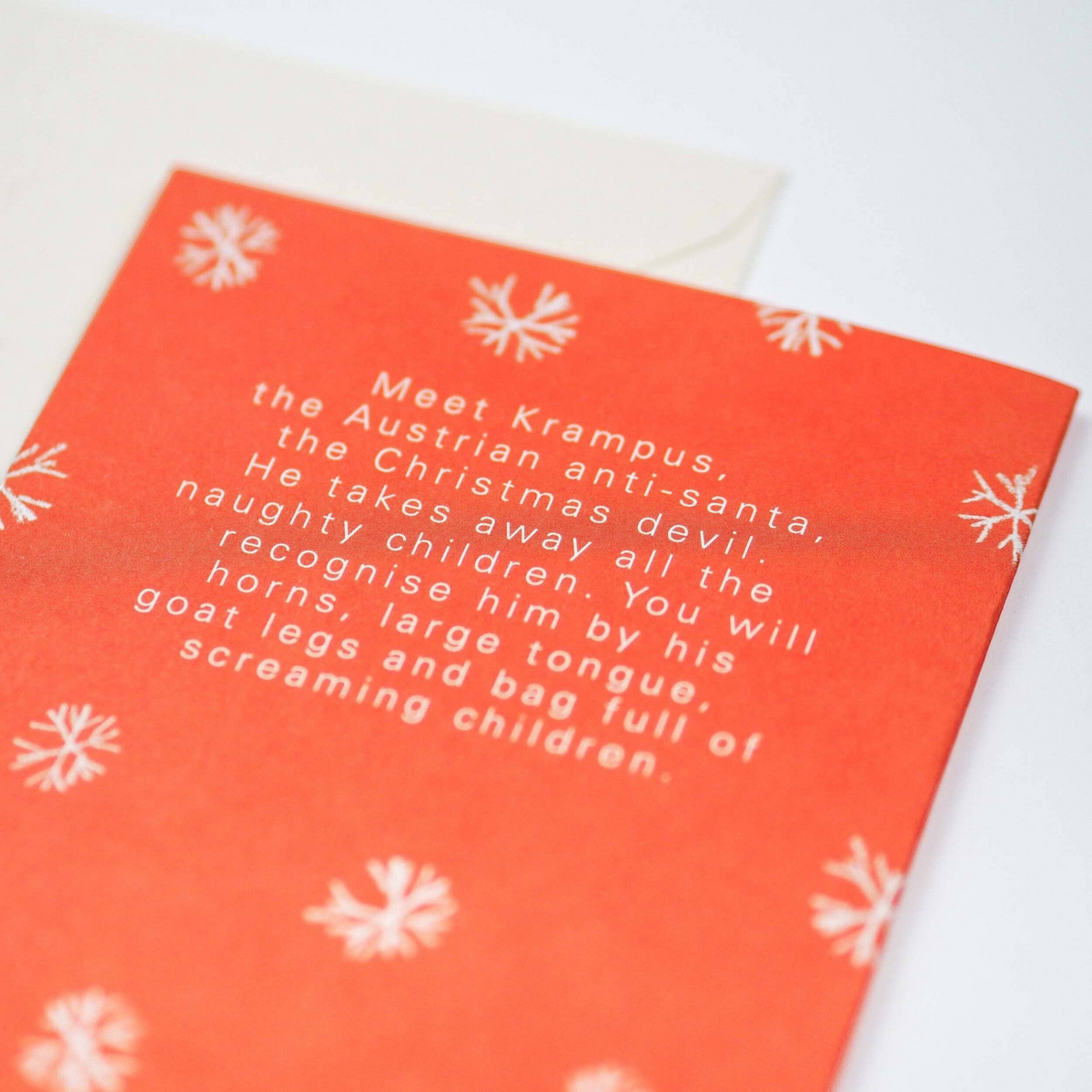 Forager Provisions LTD Krampus Christmas card back with white snowflake pattern on red background and descriptive text