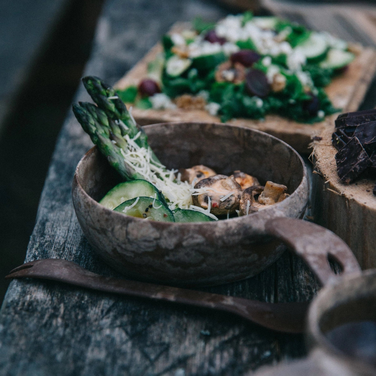 Forager Provisions LTD Kupilka 55 soup bowl filled with asparagus and mushrooms on a rustic wooden outdoor table