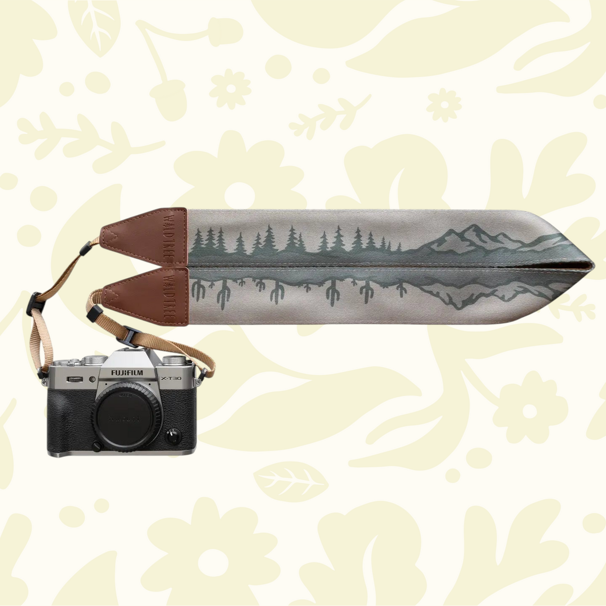 Wildtree camera strap with cacti, tree, mountains on floral backdrop, styled with camera. Best DSLR accessory 2024.