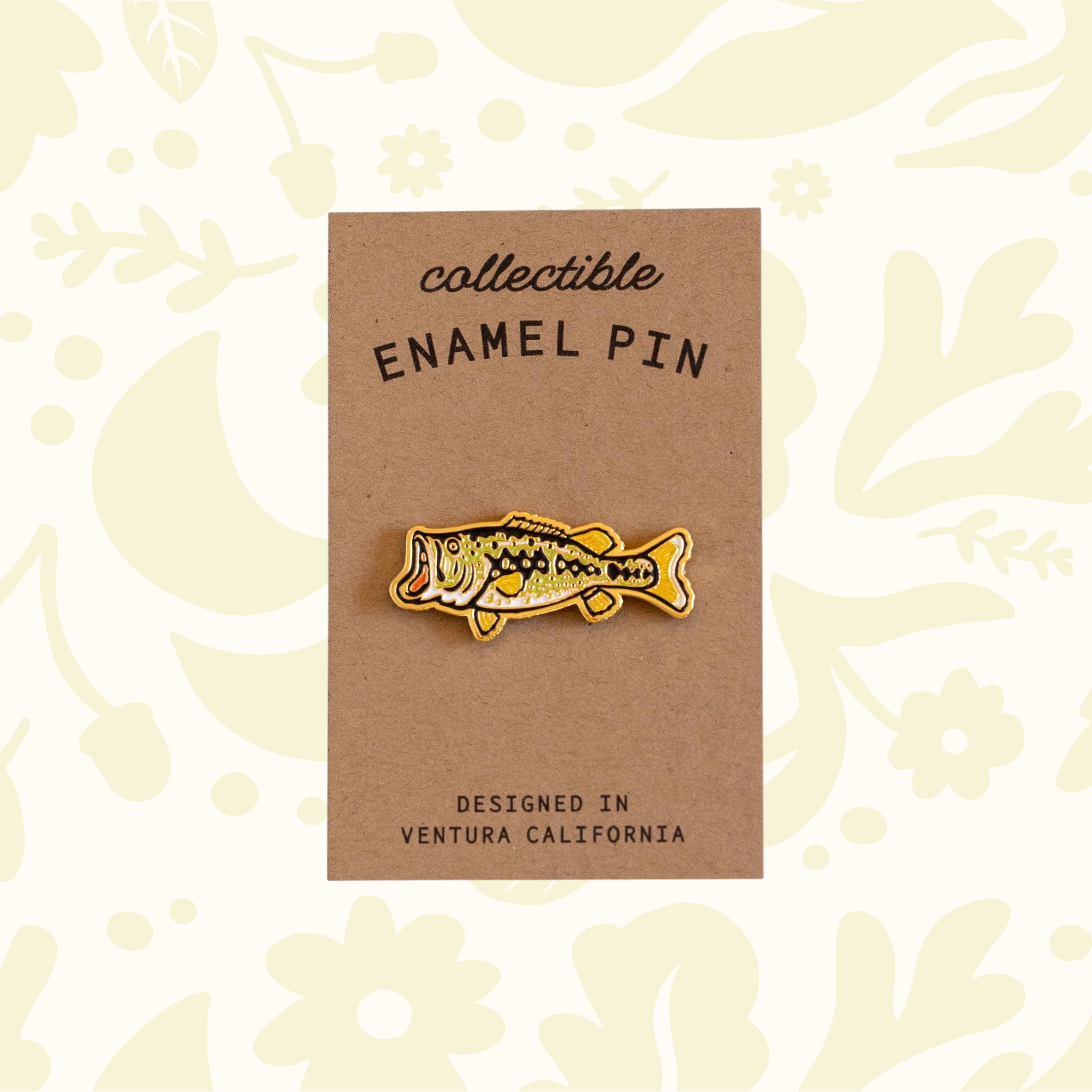 Forager Provisions LTD metallic gold largemouth bass enamel pin on a kraft cardstock backing.