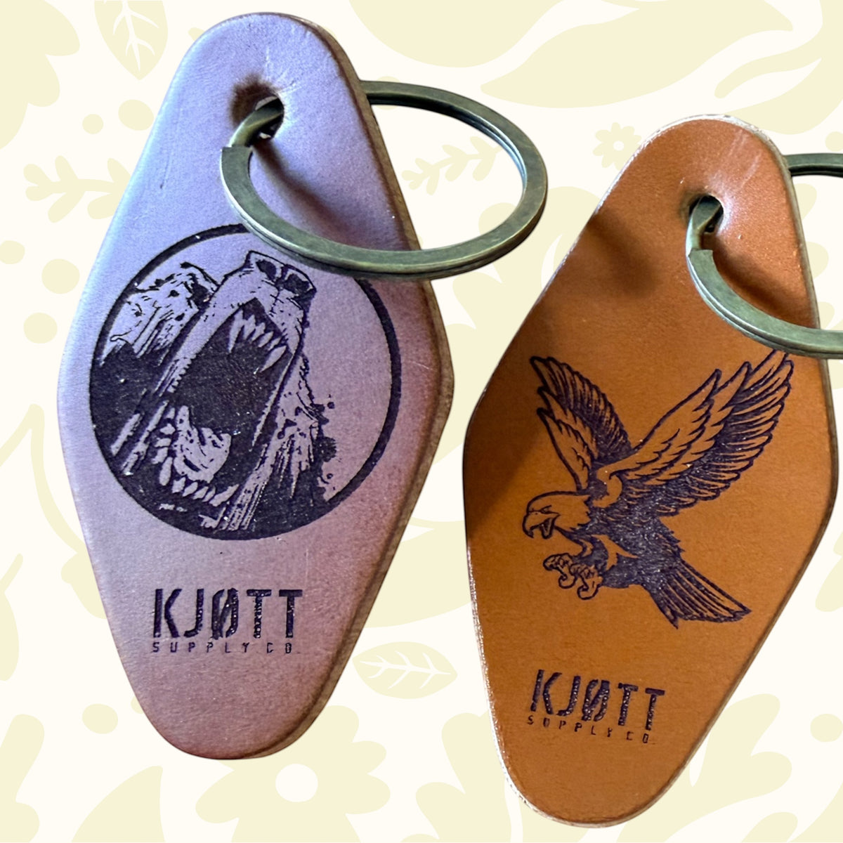 Forager Provisions LTD Kjøtt Supply Co leather motel keyrings with bear and eagle engravings on a wooden surface