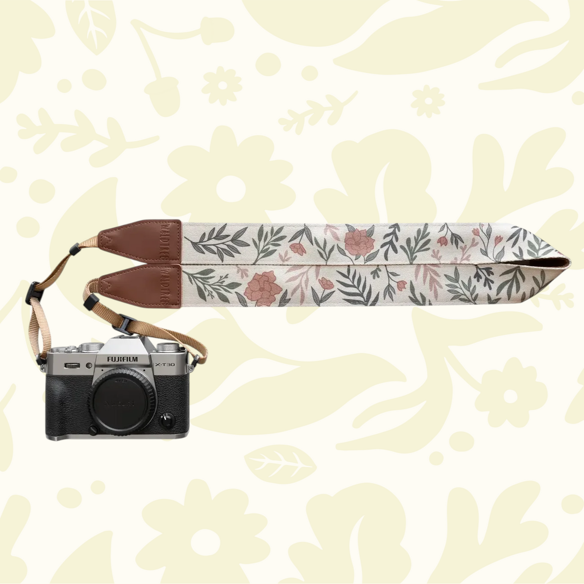 Forager Provisions LTD Wildtree Moody Flower camera strap with floral print, brown faux leather ends, and Fujifilm camera.