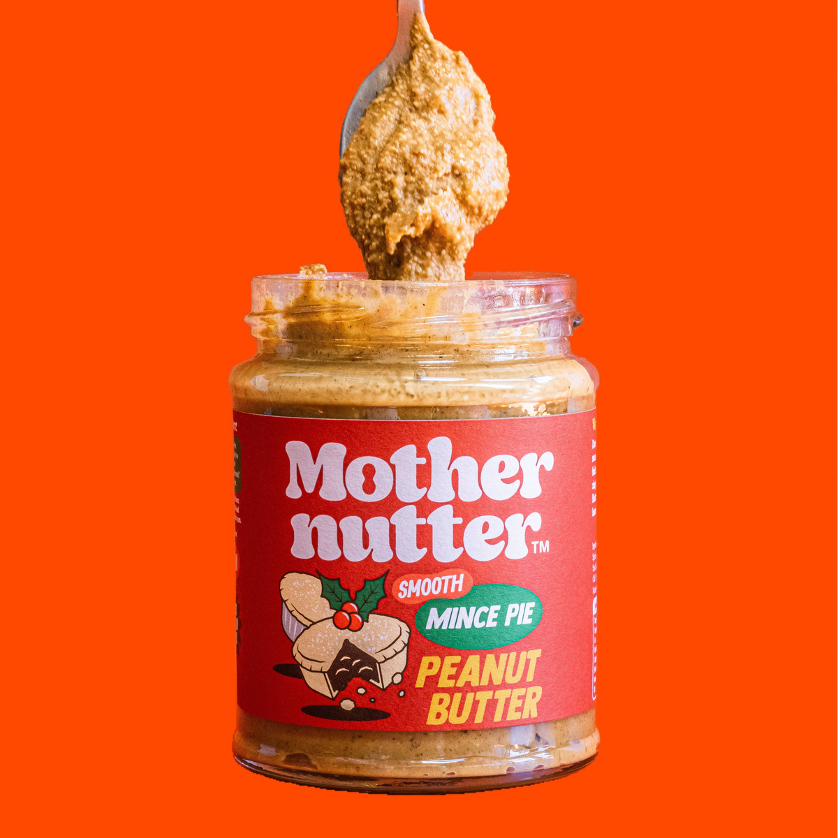 Forager Provisions LTD Mothernutter smooth mince pie peanut butter in a glass jar with a spoonful being lifted out.