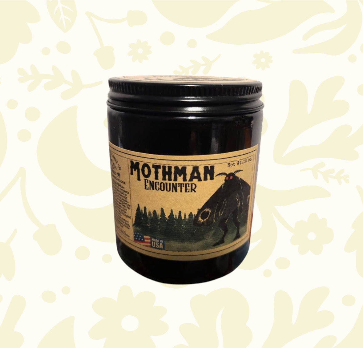 Forager Provisions LTD Mothman Encounter candle in a black jar with vintage-style cryptid label and forest illustration