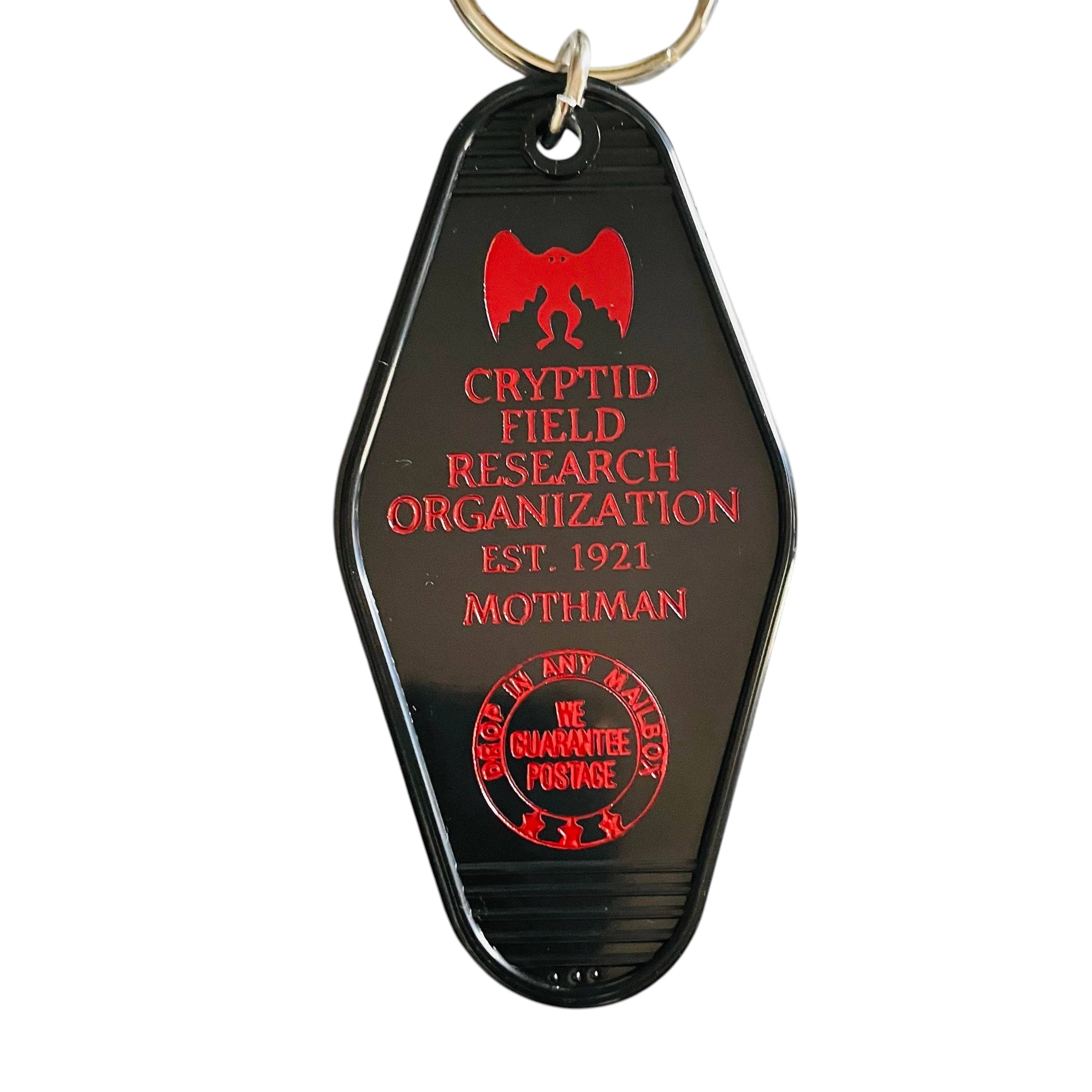 Forager Provisions LTD vintage style black motel key fob with red Mothman Cryptid Field Research Organization graphic