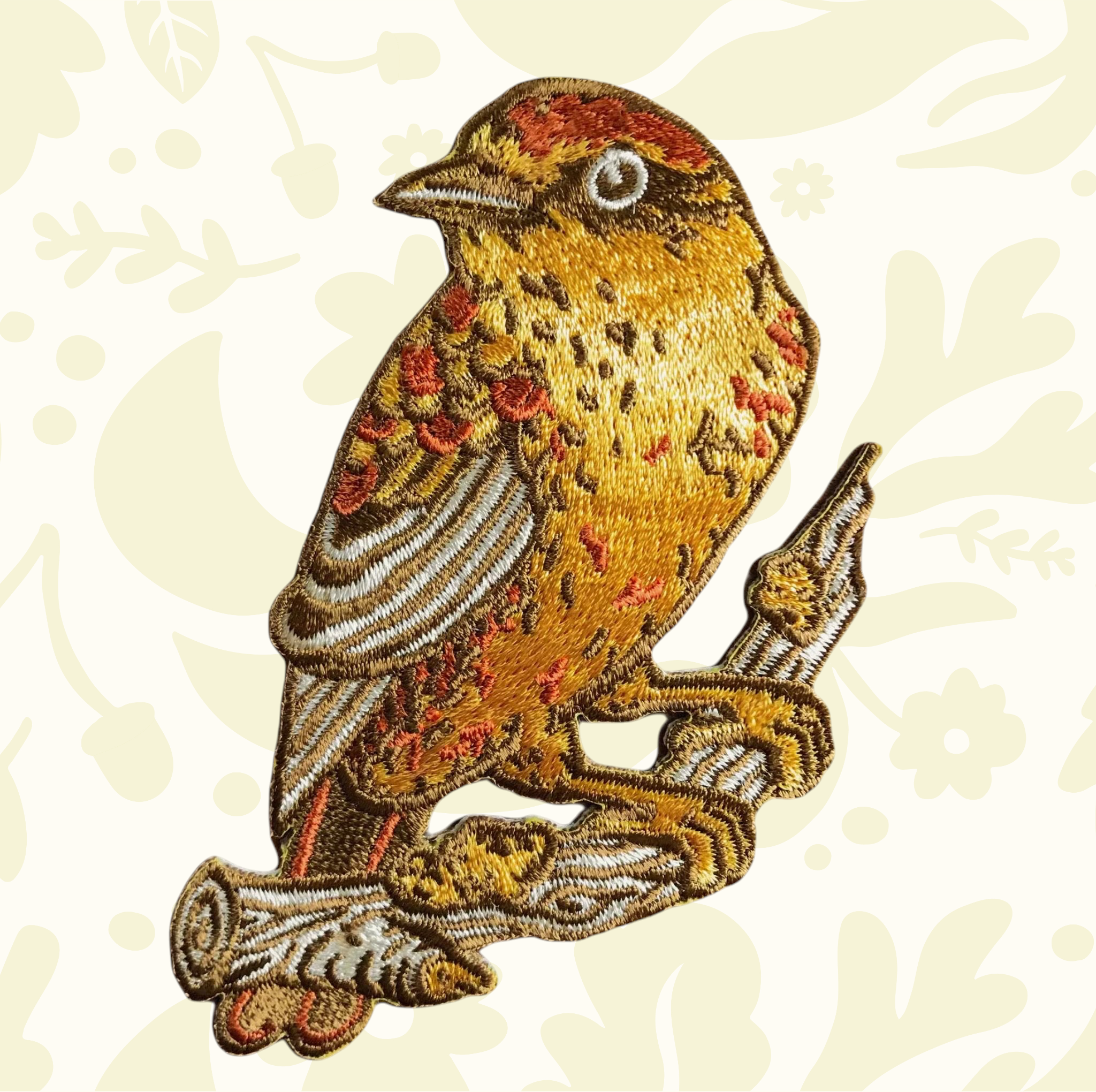 Forager Provisions LTD embroidered Palm Warbler bird iron-on patch in mustard yellow and orange tones on a branch.