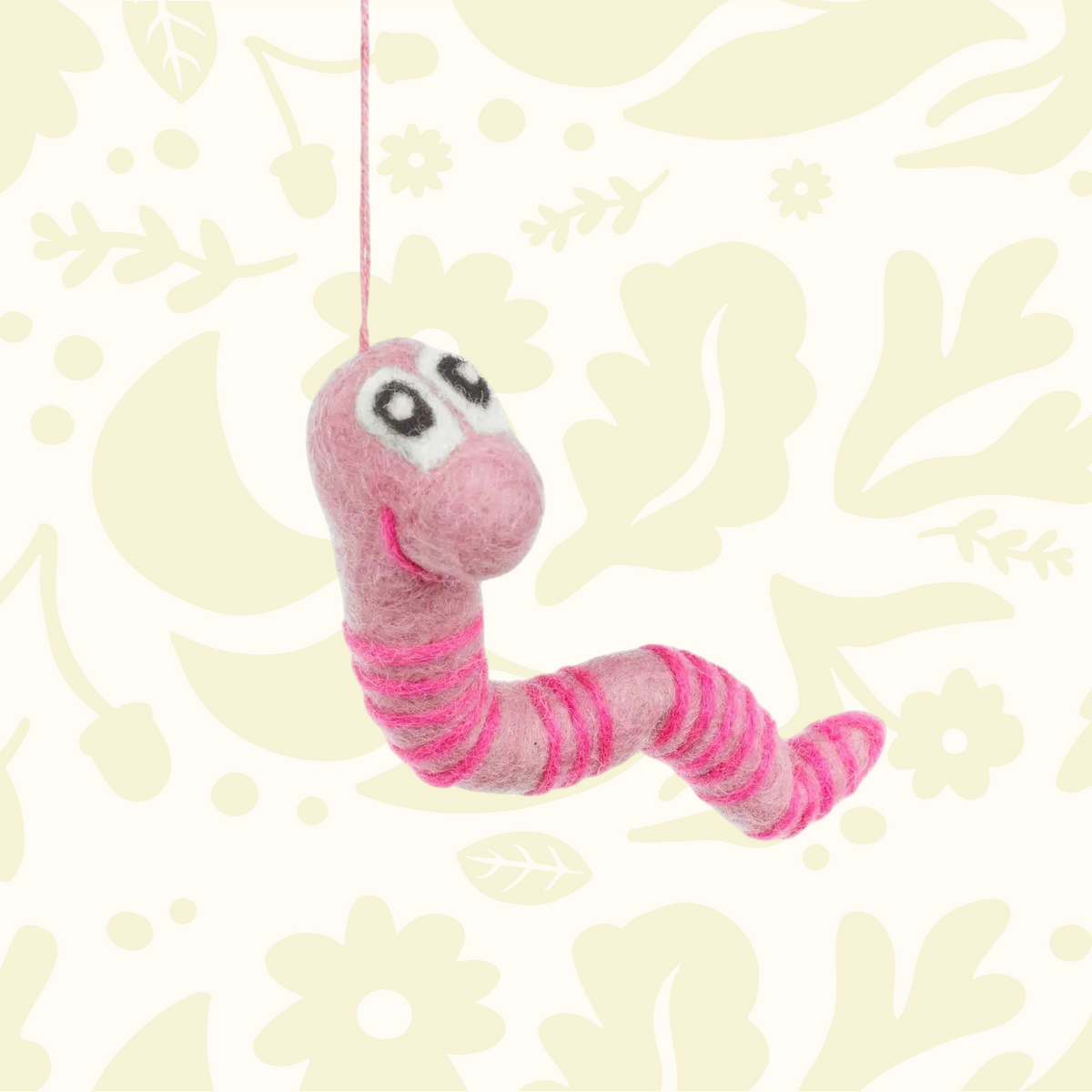 Forager Provisions LTD handmade pink felt worm decoration with striped pattern and hanging string on floral background