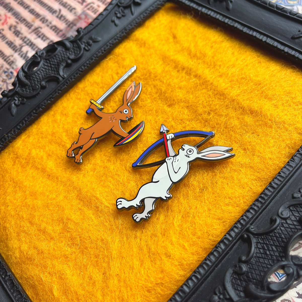 Forager Provisions LTD Beeftopia enamel pins featuring a brown rabbit with a sword and a white rabbit with a bow.