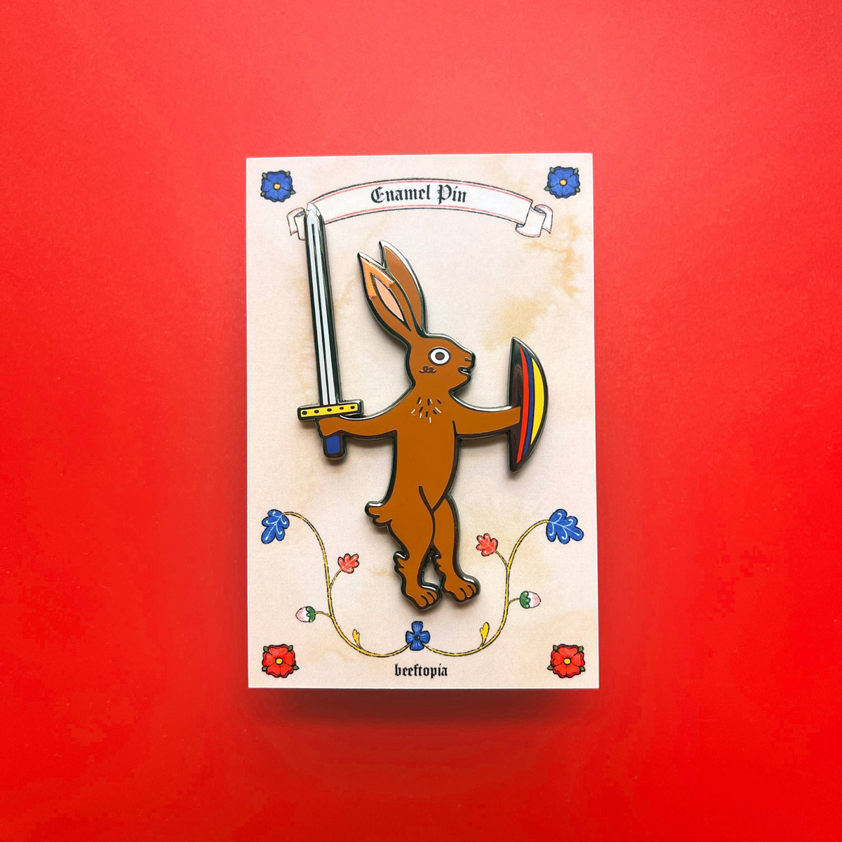Forager Provisions LTD Beeftopia enamel pin featuring a brown rabbit knight with a sword and shield on display card