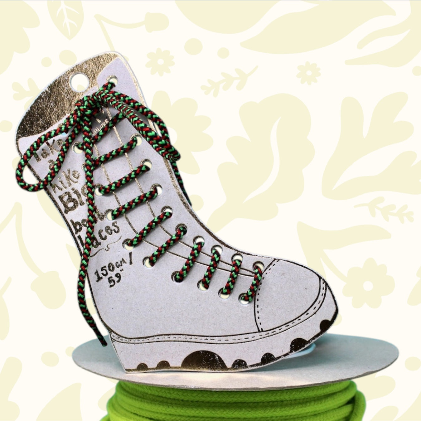 Ark paper boot with red, green, black Big Boot Laces on neon green cord; dreamy branded backdrop for trendy footwear lovers.