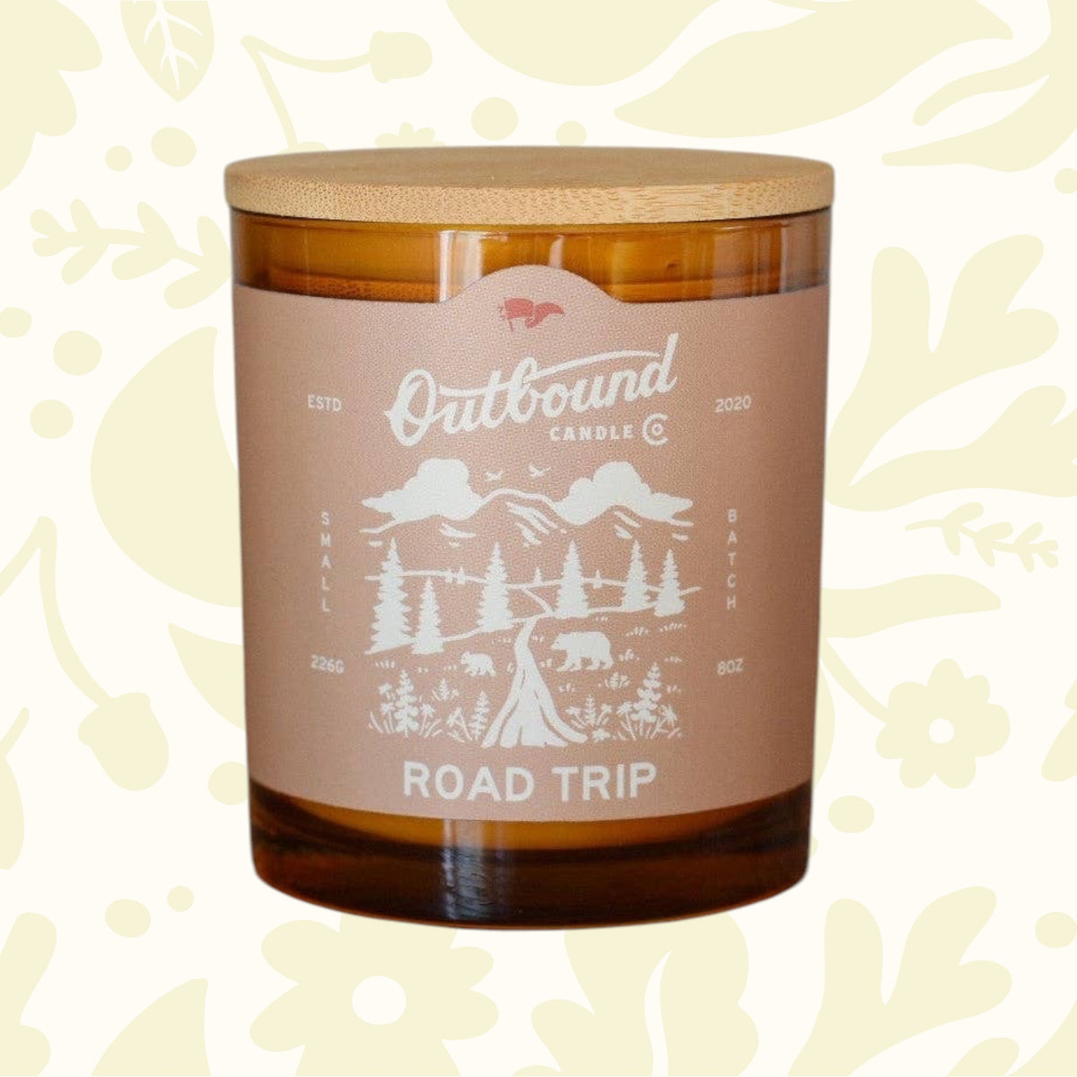 Forager Provisions LTD Road Trip 8oz soy candle in an amber glass jar with a bamboo lid and mountain landscape label.