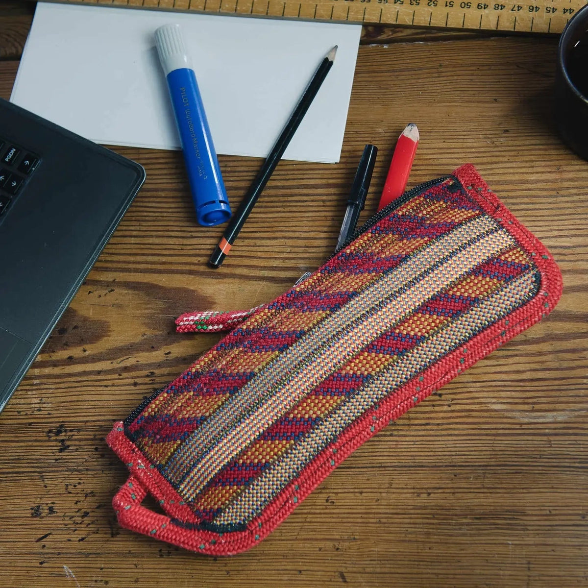 Forager Provisions LTD Scavenger large zip pouch in Fire colourway made from recycled climbing rope on a wooden desk.