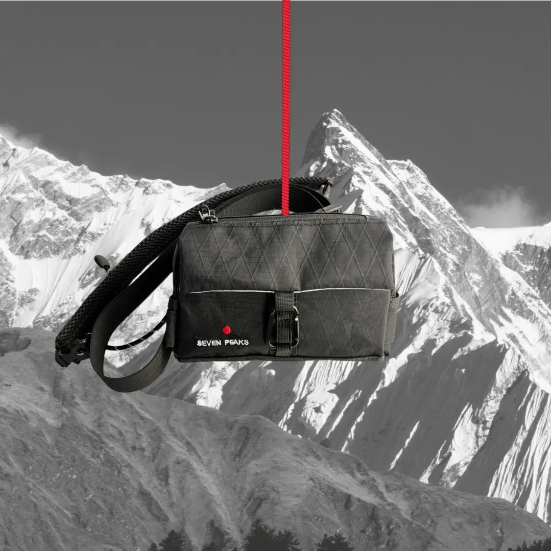 Forager Provisions LTD Seven Peaks all-black water-resistant fanny pack hanging against a mountain backdrop.