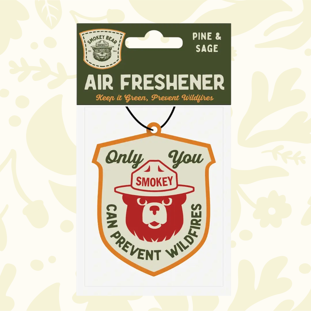 Forager Provisions LTD Smokey Bear hanging car air freshener with pine and sage scent in a shield-shaped design.