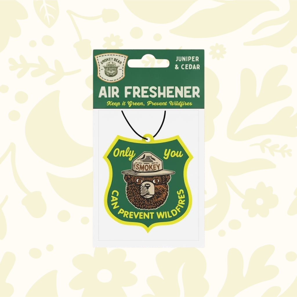 Forager Provisions LTD Smokey Bear air freshener in a shield shape with juniper and cedar scent for cars and closets.