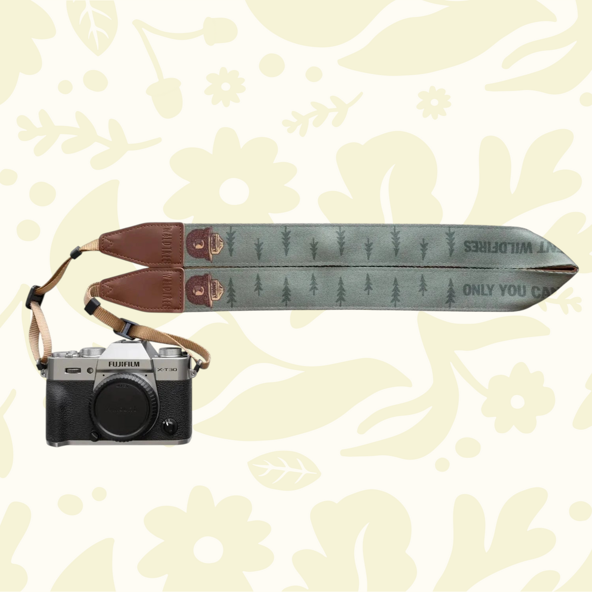 Forager Provisions LTD Smokey Bear camera strap in green polyester with brown faux suede accents attached to a camera