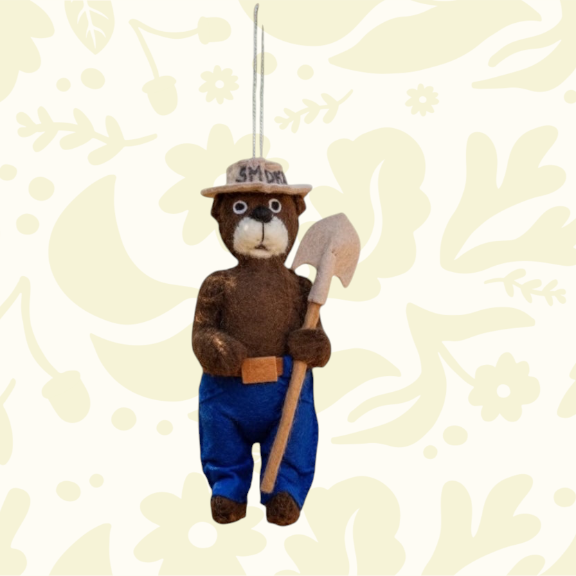 Forager Provisions LTD handmade felt Smokey Bear hanging decoration wearing a ranger hat and holding a shovel.