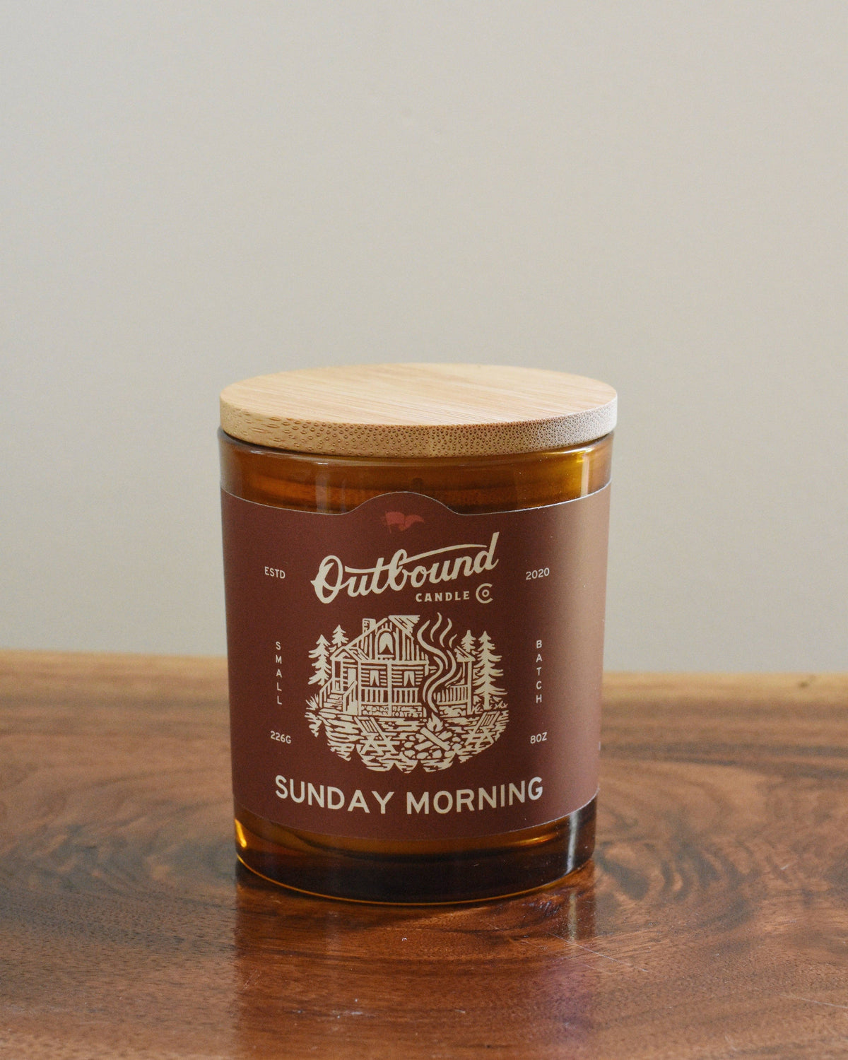 Forager Provisions LTD Outbound Candle Co Sunday Morning soy candle in an amber glass jar with a bamboo lid.