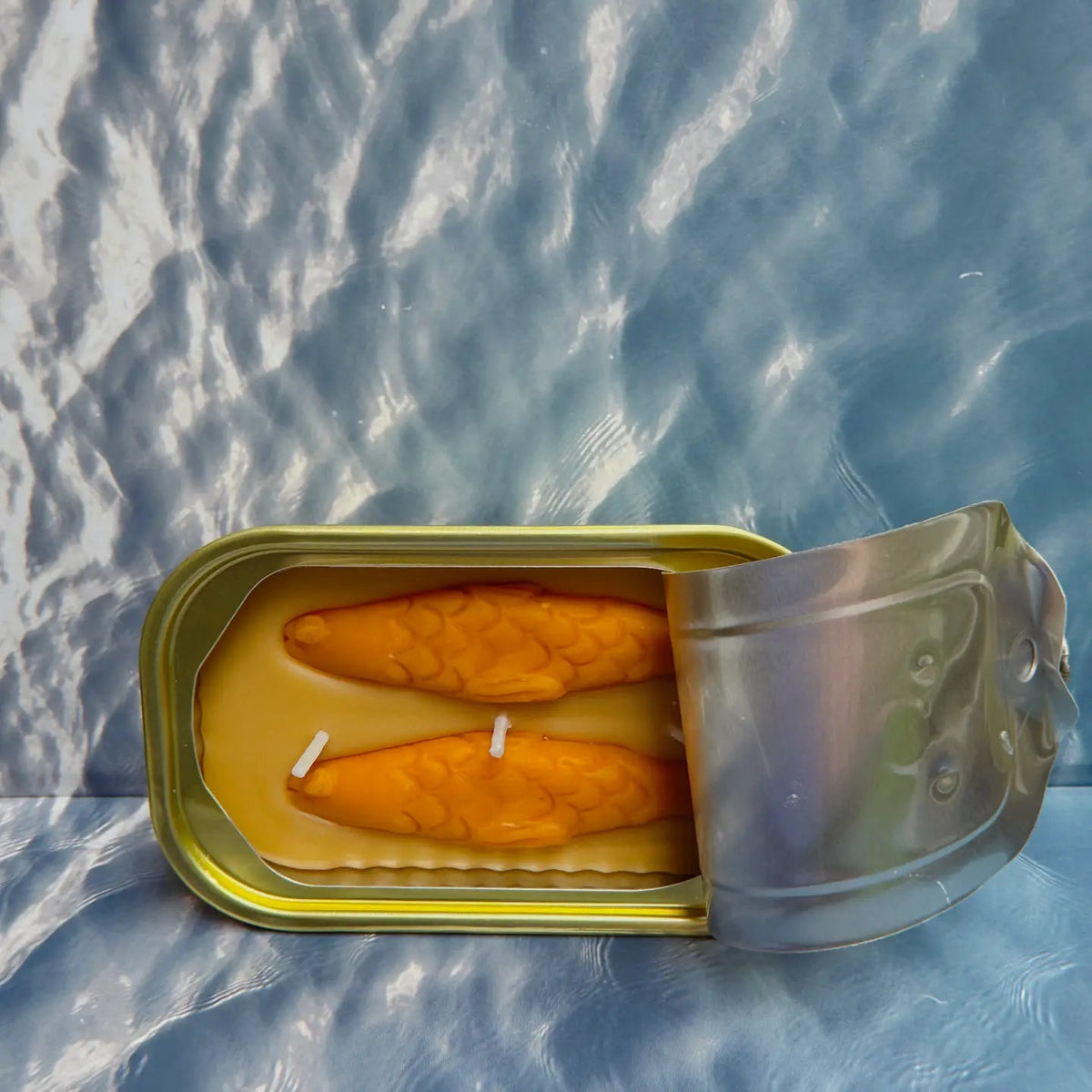 Forager Provisions LTD The Original Tinned Fish Candle in sandalwood, shaped like two orange fish in a metal tin.