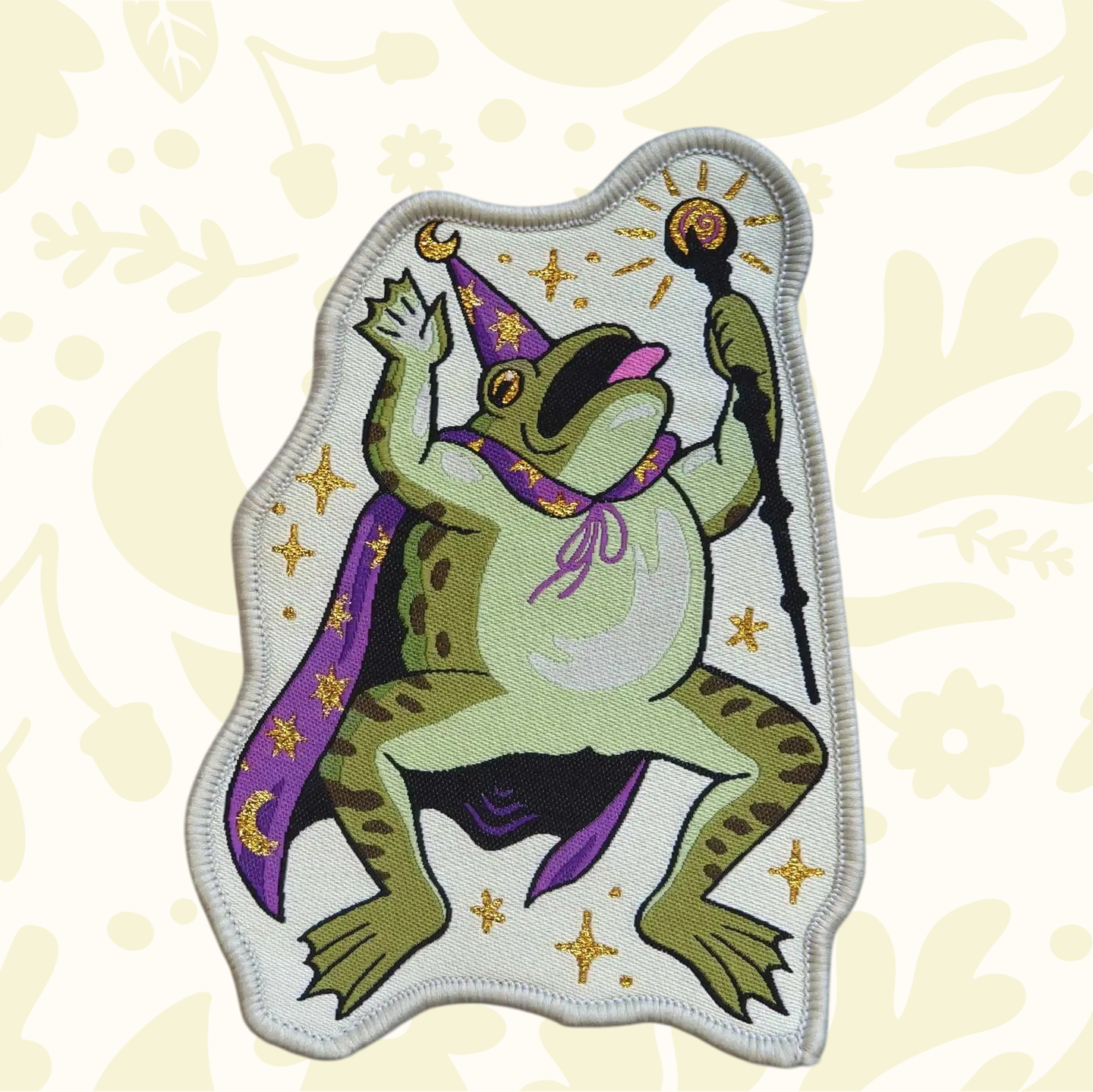 Forager Provisions LTD Cat Coven woven patch featuring a green toad wizard in a purple cape with gold star details.