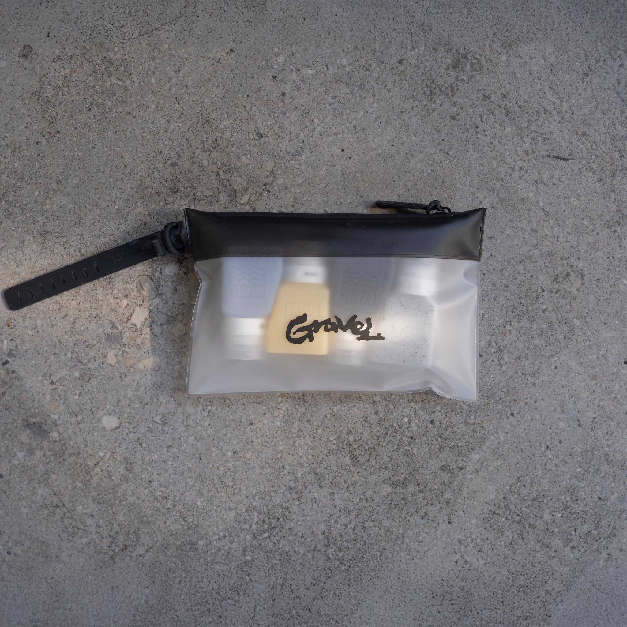 Forager Provisions LTD TSA-compliant clear toiletry bag with black trim and hang loop containing travel bottles