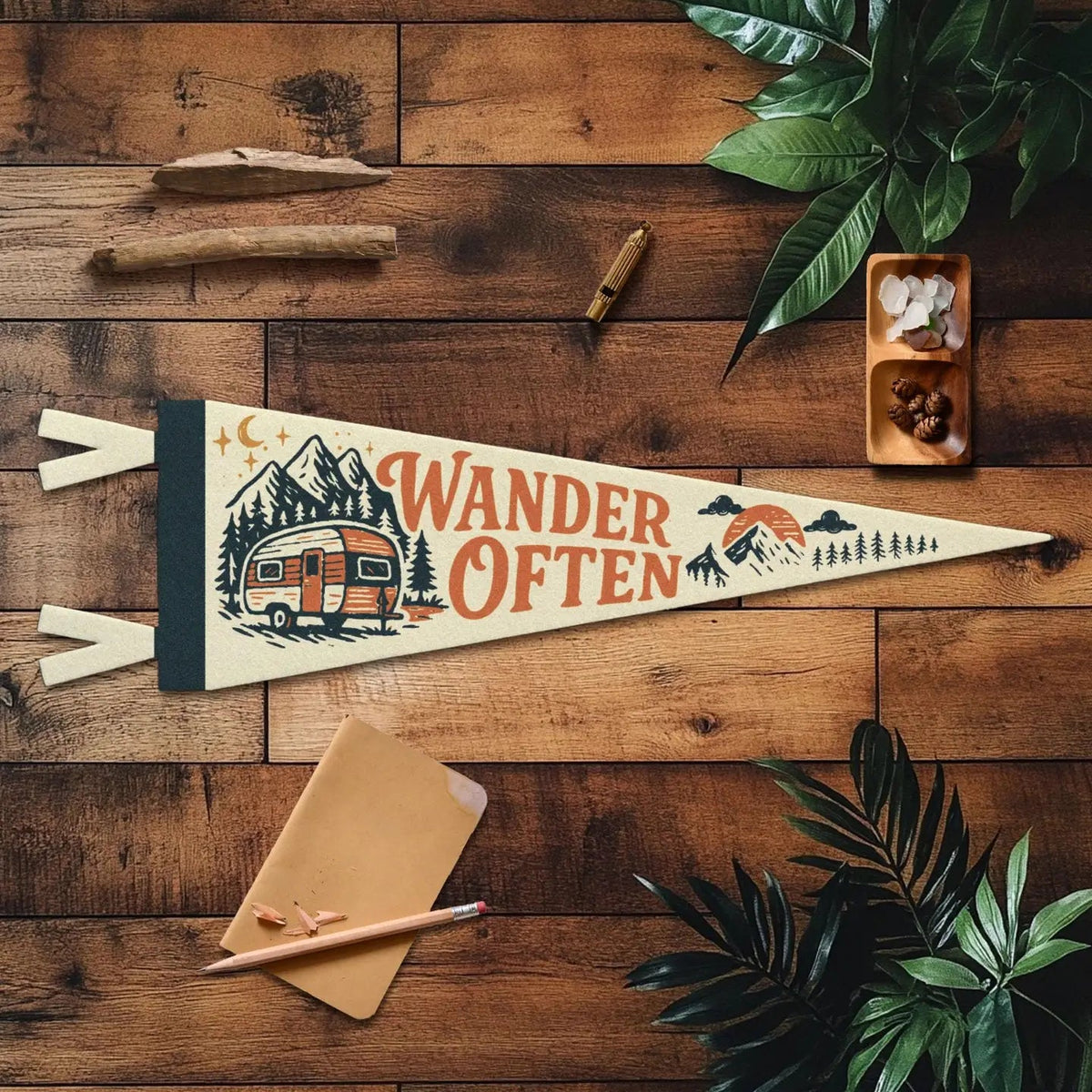 Forager Provisions LTD Wander Often felt pennant with vintage camper and mountain graphic on a wooden background.