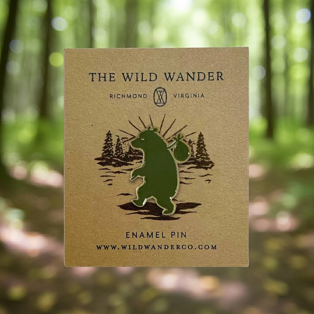 Forager Provisions LTD Wandering Bear enamel pin featuring a green bear on a branded backing card in a forest setting.