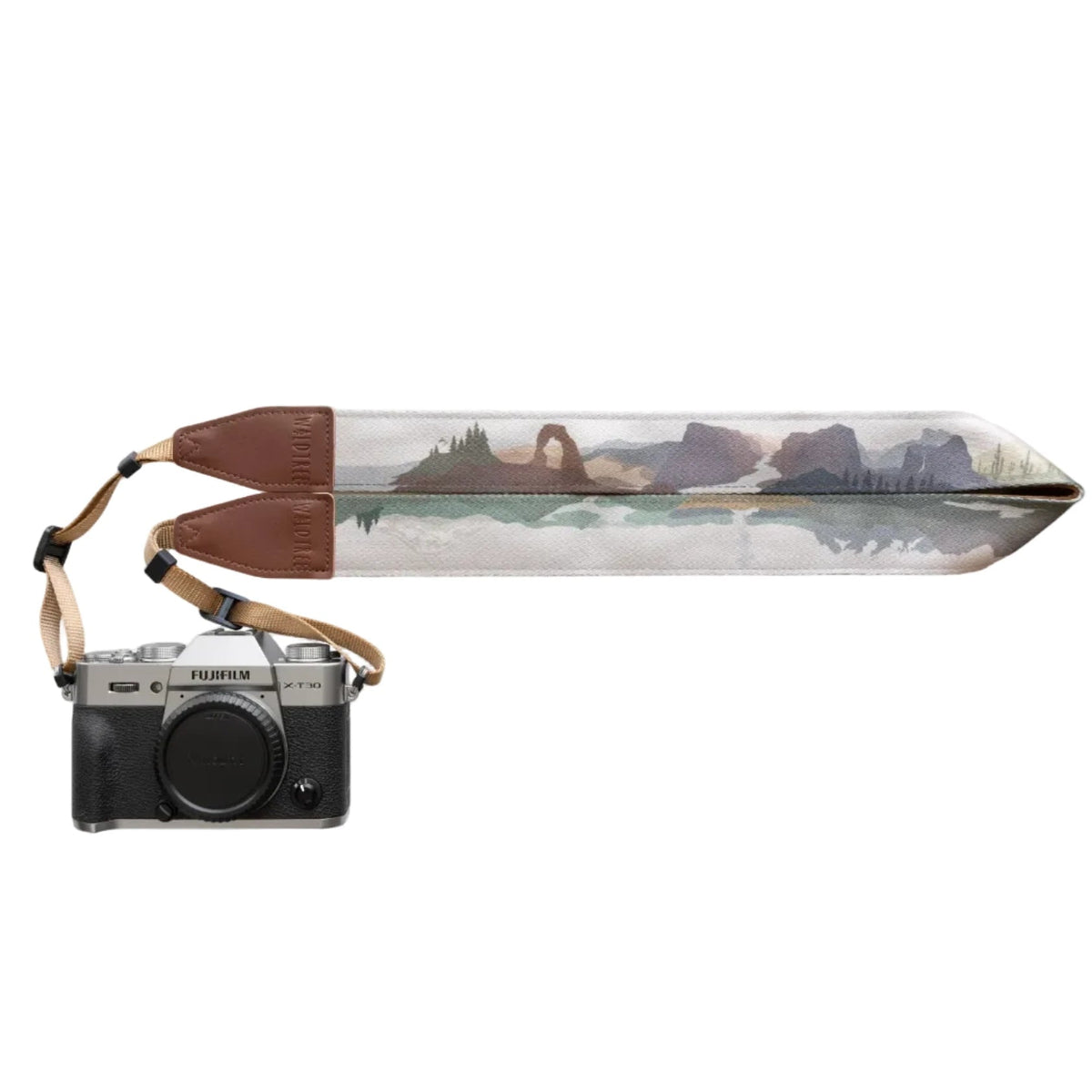 Forager Provisions LTD Wildtree camera strap featuring a landscape print with brown synthetic leather ends on a camera.