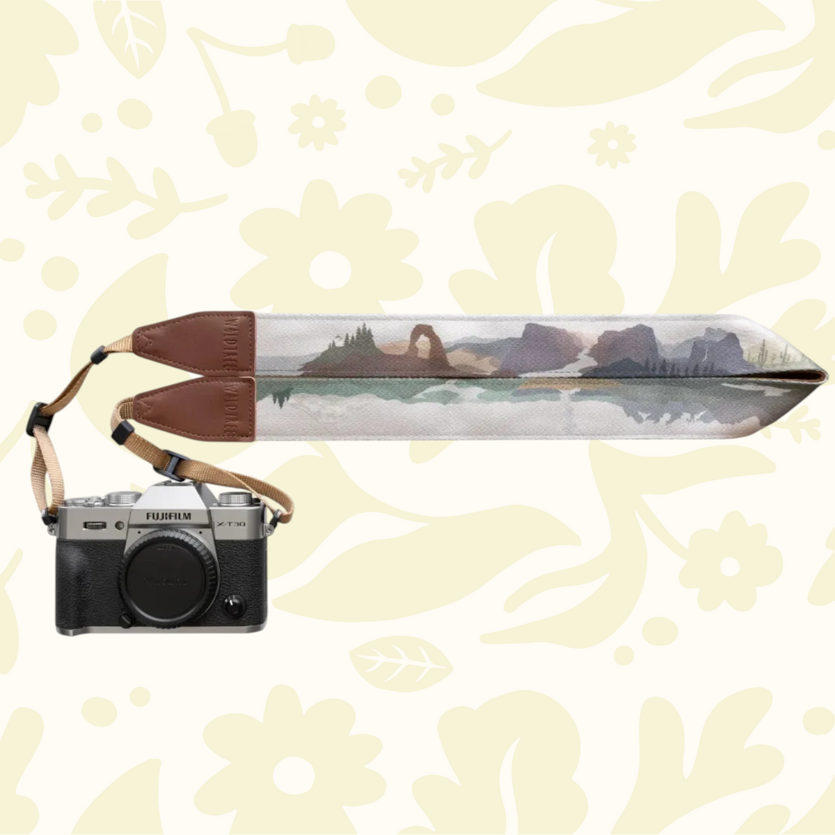Forager Provisions LTD Wildtree camera strap featuring a landscape print with brown synthetic leather ends on a camera