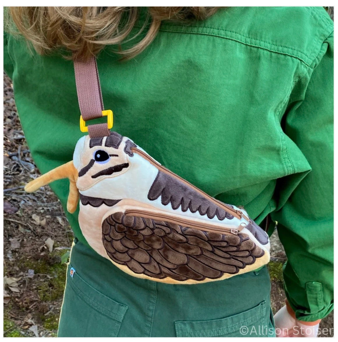 Forager Provisions LTD American Woodcock plush crossbody bag worn over the shoulder with a brown strap and yellow buckle.