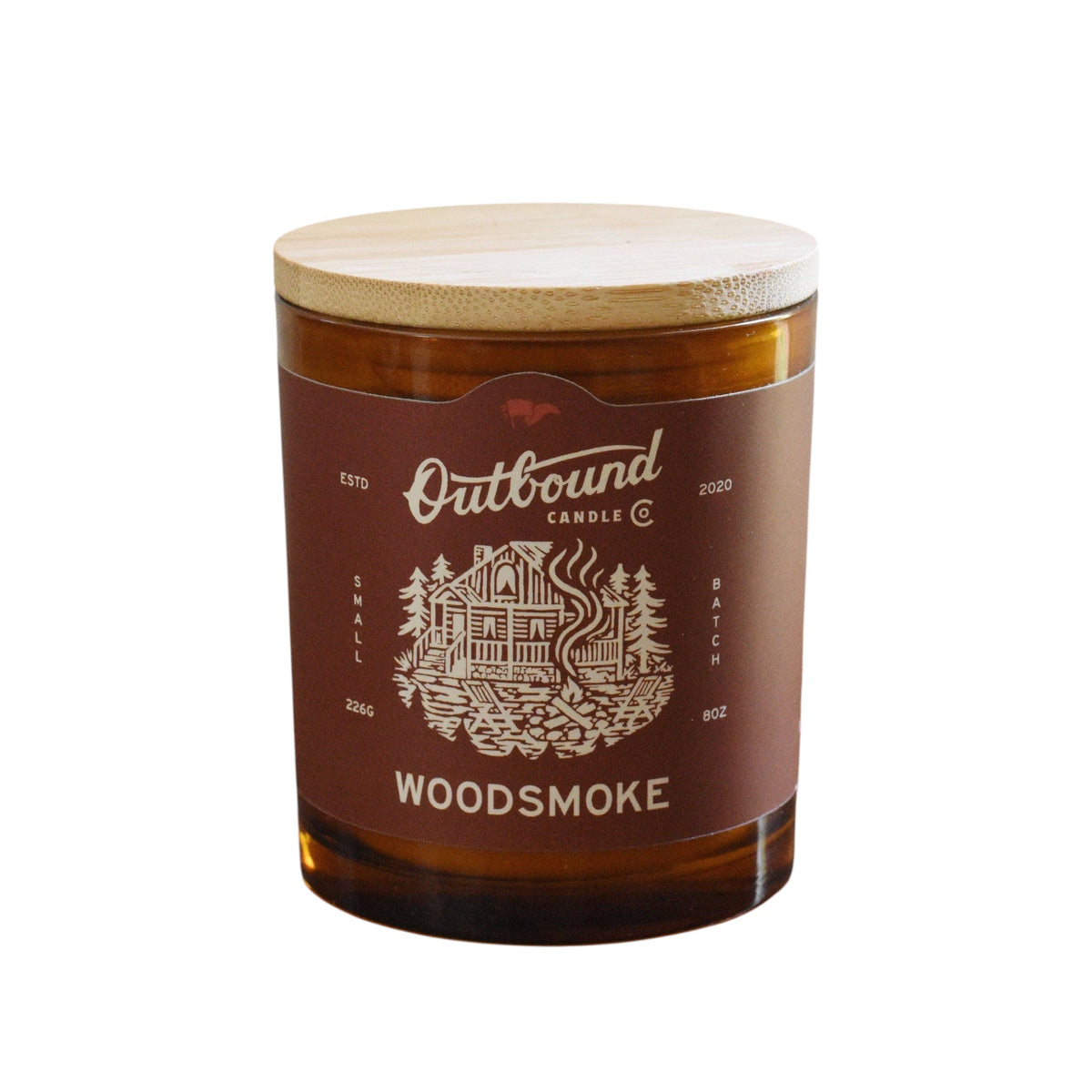 Forager Provisions LTD 8oz soy wax candle in amber glass with a bamboo lid and Woodsmoke cabin-themed label.