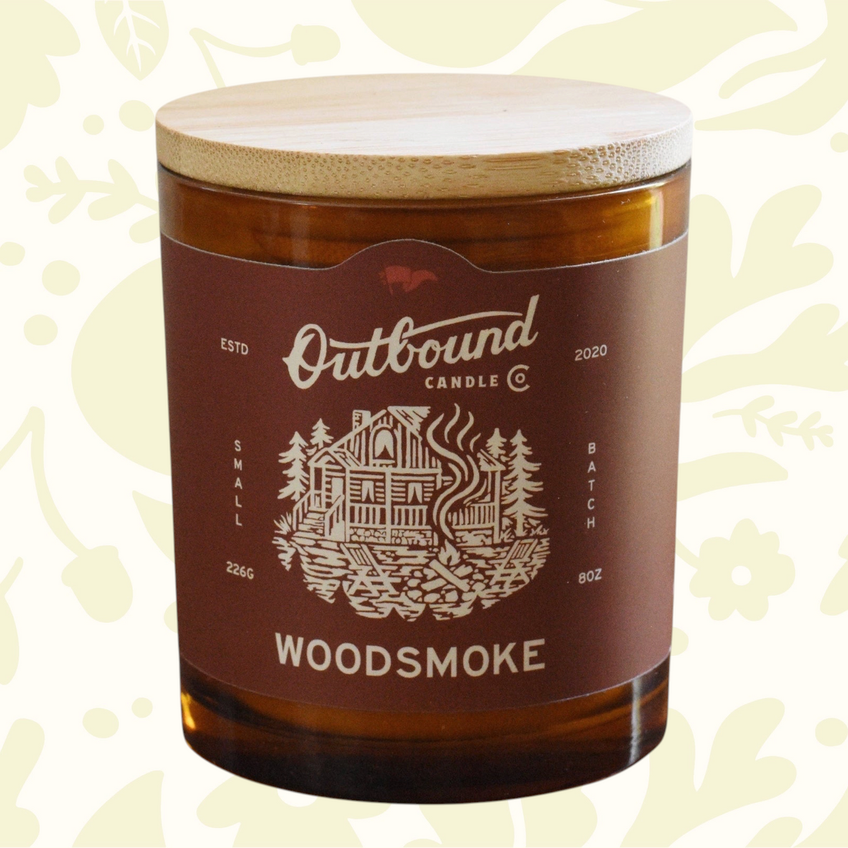 Forager Provisions LTD 8oz soy candle in amber glass with bamboo lid, featuring a cabin and campfire label design.