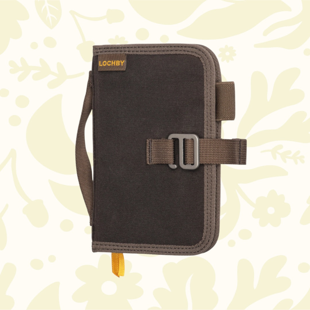 Brown Lochby Mini Field Journal, waxed canvas pouch style with handle & buckle, on floral background—perfect EDC notebook.