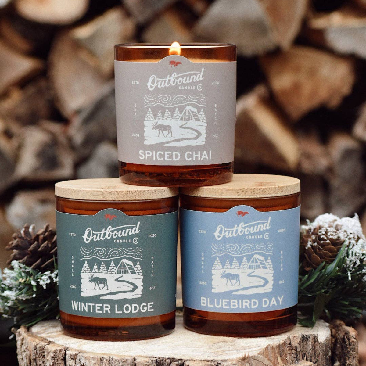 Outbound Candle Co soy candles in amber glass jars with bamboo lids, featuring Bluebird Day and other scents.